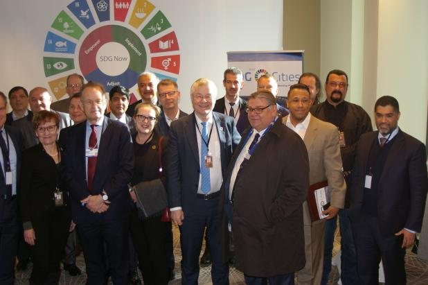 Participants at a previous SDG Lab session in front of the SDG wheel